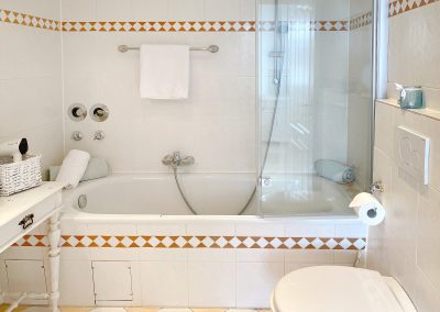 Bad mit Beistelltischchen, Badewanne mit Duschwand