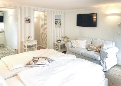 Blick auf Doppelbett u. Couch in Ferienwohnung 31, Haus Anholt