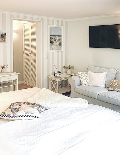 Blick auf Doppelbett u. Couch in Ferienwohnung 31, Haus Anholt